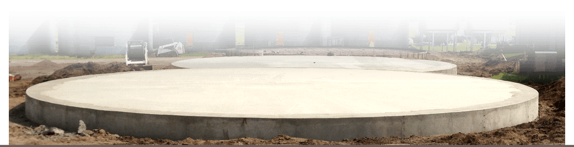 Two newly poured round concrete footings for grain bins